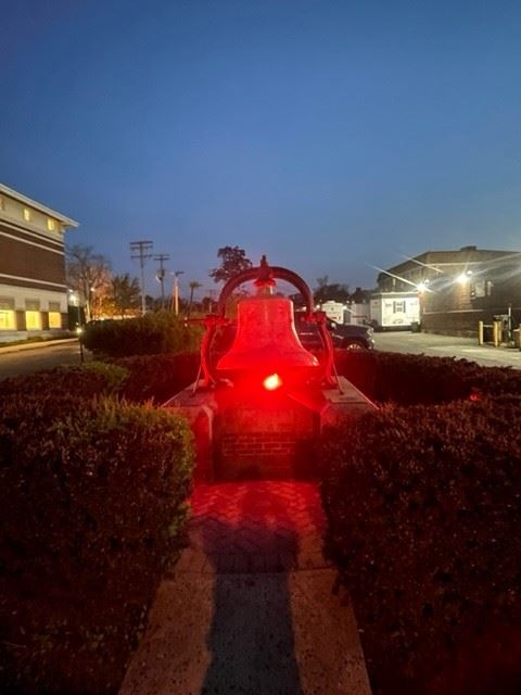 summit fire department memorial bell lit in red light