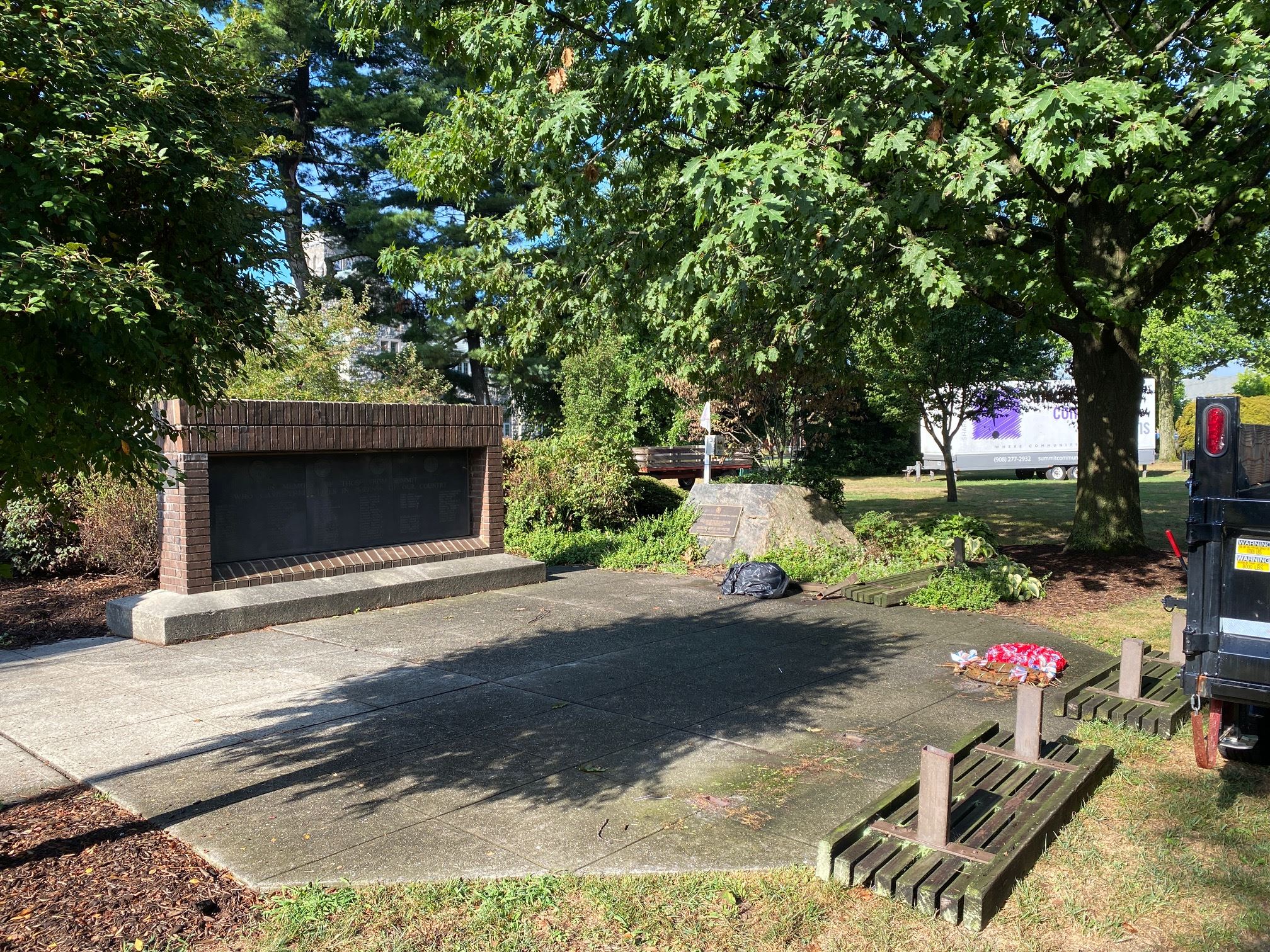 photo of monuments on village green with trees and blue sky in the background