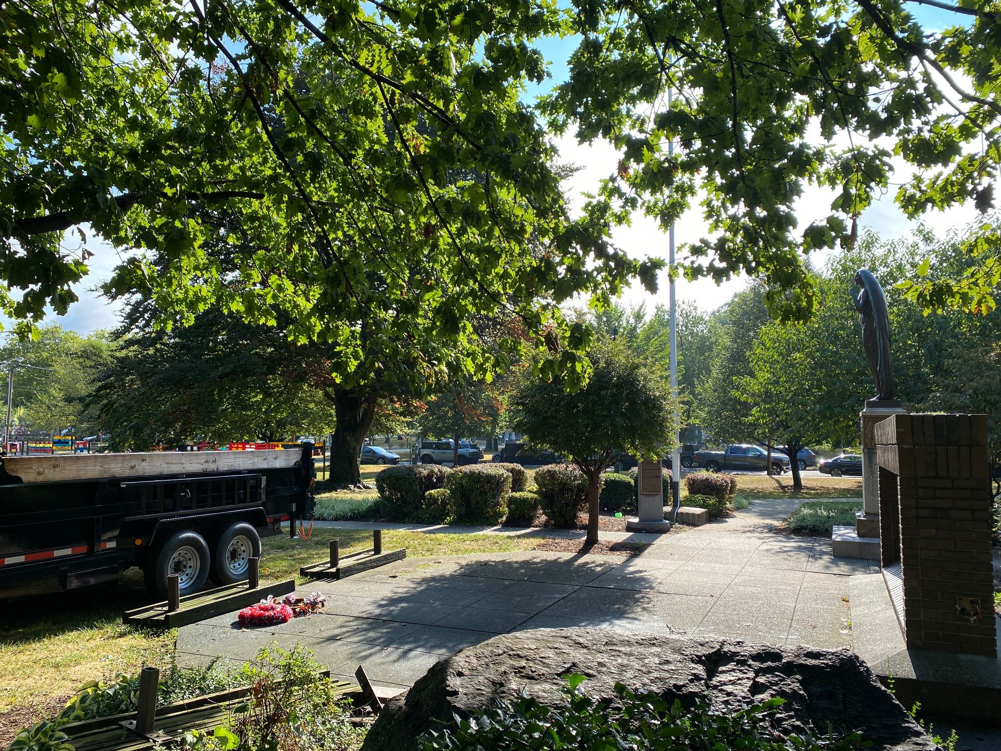 photo of monuments on village green with trees and blue sky in the background